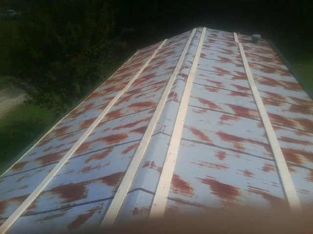 Rusted metal roof panels with new wood purlins before replacement — Storm Damage Roof Repair in Lava Hot Springs by Roofing Brothers
