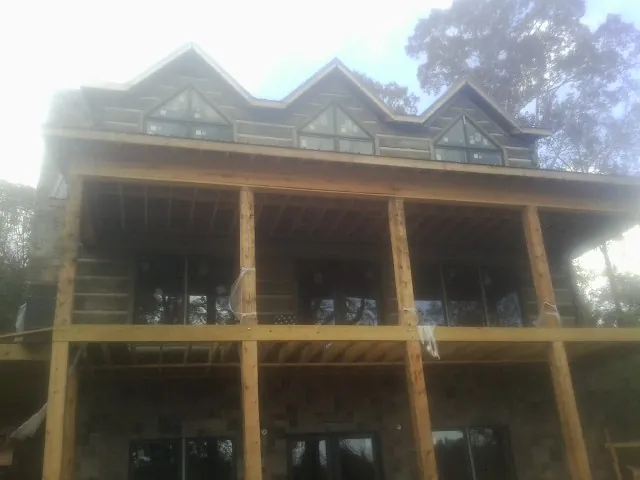 Dormers and porch framing on a large log home under construction — Roof Coating work by our crew in Lava Hot Springs