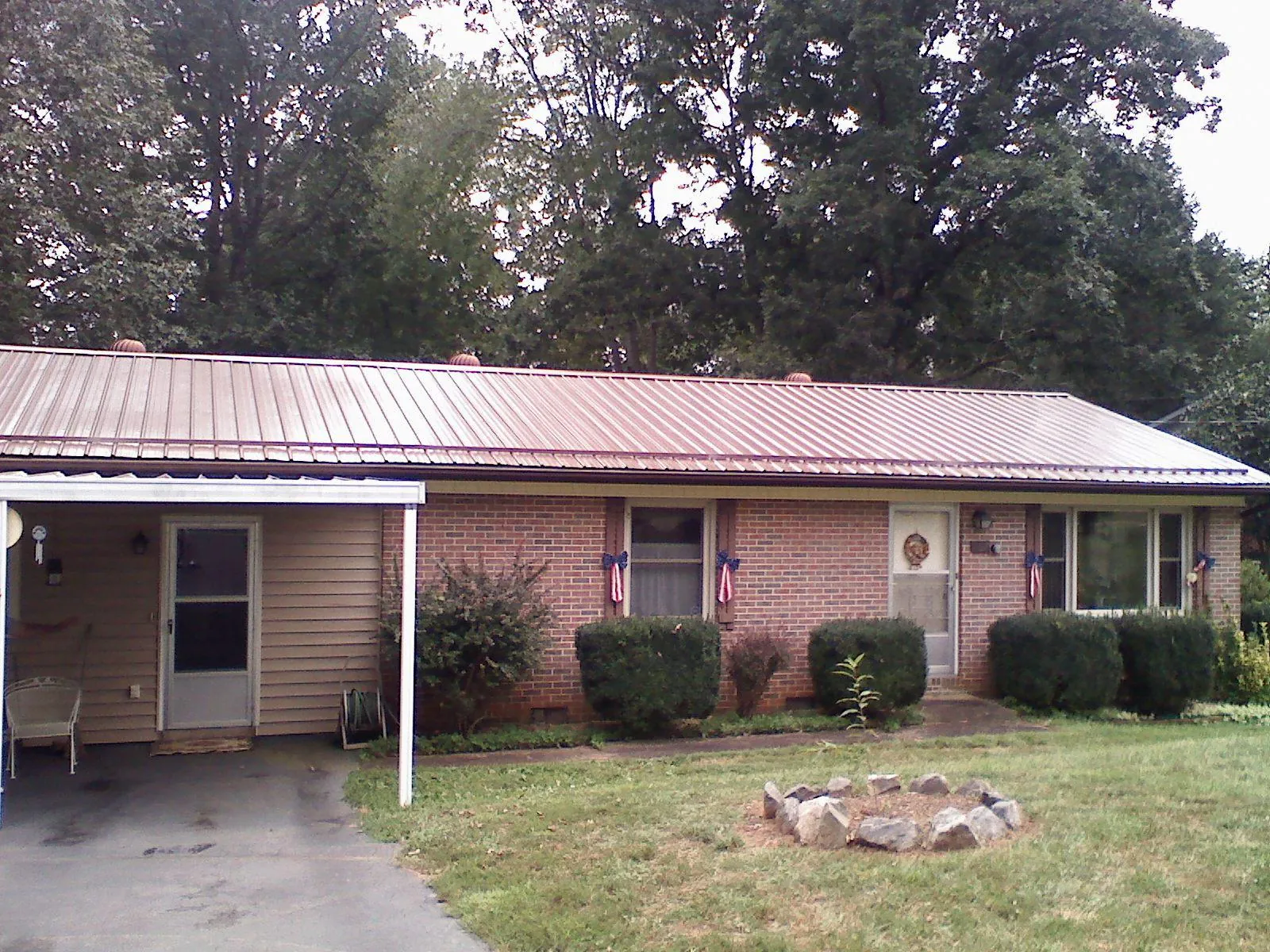 Bronze metal roof and carport on a brick ranch home — Roof Repair work by our crew in Lava Hot Springs