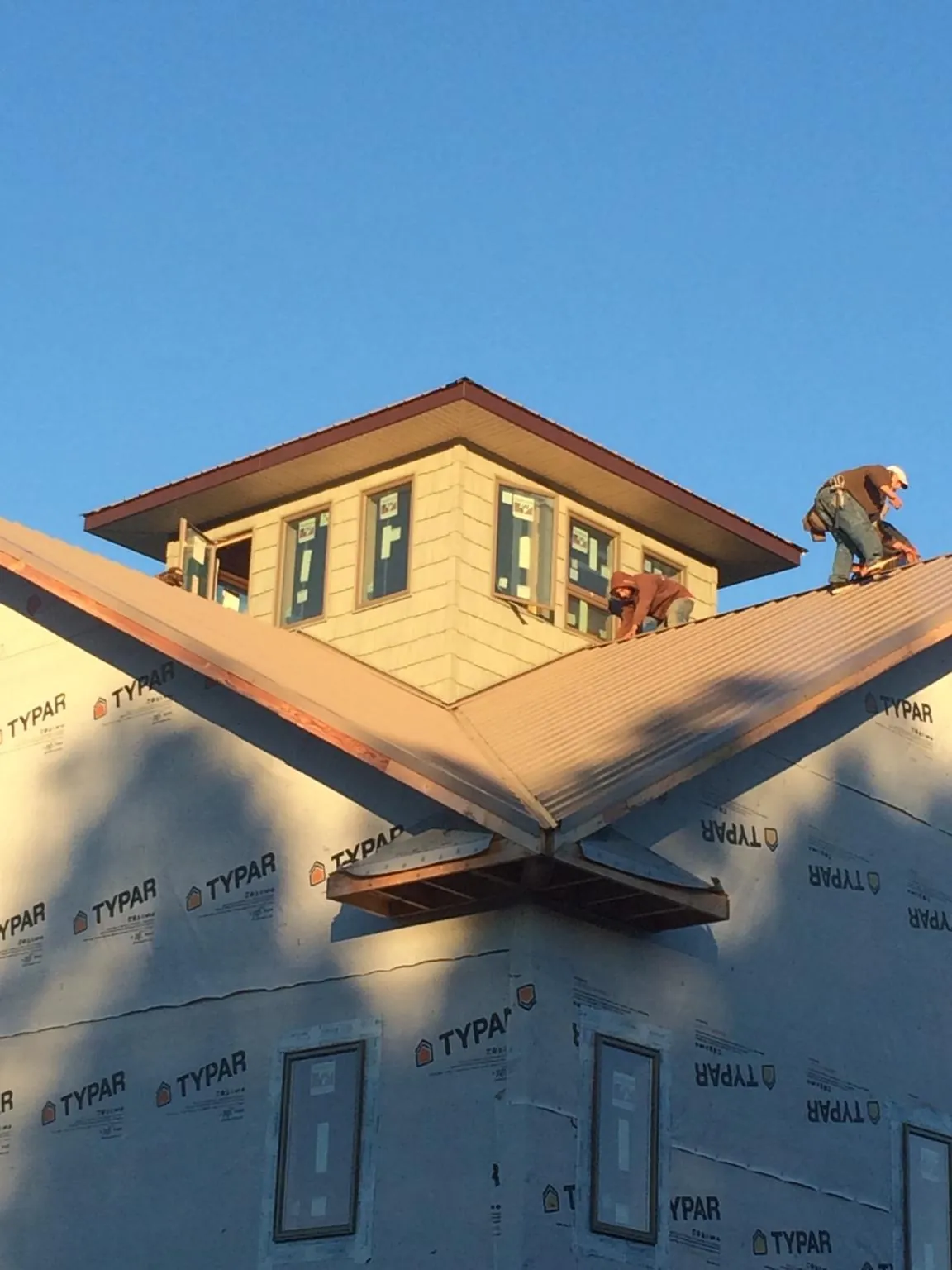 Roofers working around a rooftop cupola on a new metal roof at sunset — Roof Waterproofing in Lava Hot Springs by Roofing Brothers